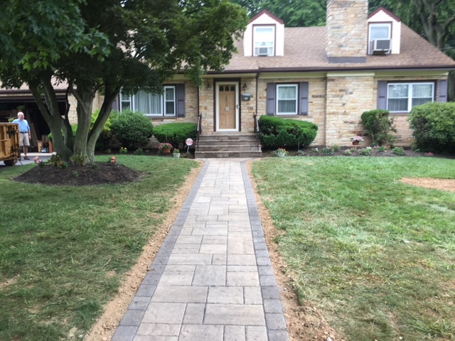 Curved paver walkway through a landscaped yard